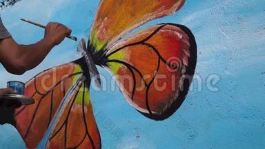 <strong>墙画</strong>家在混凝土墙上画一只蝴蝶。 时间间隔